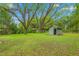 Backyard view featuring a storage shed, several trees and a large grassy area at 429 N Asheboro St, Liberty, NC 27298