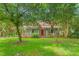Charming two-story home with a red metal roof, a inviting front porch, and mature trees in a lush green yard at 429 N Asheboro St, Liberty, NC 27298