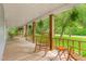 Large front porch with wooden railings, rocking chairs, side table, and hanging plants at 429 N Asheboro St, Liberty, NC 27298