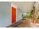 Inviting front porch with a wooden rocking chair, bright red door, and outdoor rug at 429 N Asheboro St, Liberty, NC 27298
