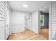 Hallway with wooden floors, white walls, and multiple entrances to other rooms at 429 N Asheboro St, Liberty, NC 27298