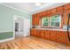 Traditional kitchen featuring knotty pine cabinets, black appliances, hardwood floors and view to second room at 429 N Asheboro St, Liberty, NC 27298