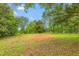 Acreage with mature trees and a mix of open space and wooded areas at 429 N Asheboro St, Liberty, NC 27298