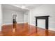 Spacious living room featuring gleaming hardwood floors, fireplace, white trim, and ceiling fan at 429 N Asheboro St, Liberty, NC 27298