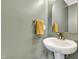 Clean powder room featuring a pedestal sink with bronze fixtures and a decorative mirror at 4405 Aubaun Way, Knightdale, NC 27545