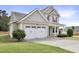 Side view of home featuring a well-manicured lawn, two-car garage, and classic exterior finishes at 4405 Aubaun Way, Knightdale, NC 27545