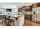 Open kitchen with a granite island, stainless steel appliances, and dark wood cabinetry at 4405 Aubaun Way, Knightdale, NC 27545
