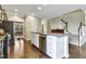 Bright kitchen features an island with granite counters, wooden floors, and stainless steel appliances at 4405 Aubaun Way, Knightdale, NC 27545