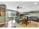 Inviting living room featuring a comfortable green sofa, ceiling fan, and custom shelves filled with collectibles at 4405 Aubaun Way, Knightdale, NC 27545