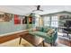 Cozy living room with a comfortable green sofa, movie posters, and natural light from the adjacent windows at 4405 Aubaun Way, Knightdale, NC 27545
