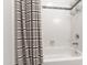 Bright bathroom featuring a shower with white tiles and a stylish striped curtain at 4900 Old Millcrest Ct, Raleigh, NC 27609
