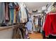 Walk-in closet featuring rods and shelves for organized storage of clothes, bags, and shoes, with hardwood floors at 4900 Old Millcrest Ct, Raleigh, NC 27609