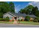 Charming brick home with a gray roof, lush landscaping, and inviting curb appeal, offering classic suburban comfort at 4900 Old Millcrest Ct, Raleigh, NC 27609
