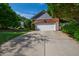 A well-maintained house featuring a brick facade, an attached garage, a driveway, and beautifully landscaped surroundings at 4900 Old Millcrest Ct, Raleigh, NC 27609