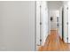 Hallway with hardwood floors, white trim and doors, leading to different rooms in the house at 4900 Old Millcrest Ct, Raleigh, NC 27609