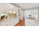 Bright kitchen featuring white cabinets, hardwood floors, stainless steel appliances, and a breakfast nook with shuttered windows at 4900 Old Millcrest Ct, Raleigh, NC 27609