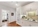 Charming kitchen featuring white cabinets, stainless steel appliances, hardwood floors, and an adjacent entryway at 4900 Old Millcrest Ct, Raleigh, NC 27609