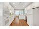 Bright, all-white kitchen with hardwood floors, modern appliances, and plenty of counter space at 4900 Old Millcrest Ct, Raleigh, NC 27609