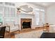 Living room with brick fireplace, hardwood floors, white shutters, and natural light at 4900 Old Millcrest Ct, Raleigh, NC 27609