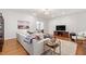 Bright living room featuring hardwood floors, couch, decor, television, and natural light at 4900 Old Millcrest Ct, Raleigh, NC 27609