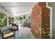 Screened porch with a brick fireplace, wooden flooring, and overhead lighting, perfect for outdoor relaxation at 4900 Old Millcrest Ct, Raleigh, NC 27609