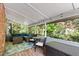 Screened-in porch featuring outdoor seating, wood decking, a ceiling, and green forest views at 4900 Old Millcrest Ct, Raleigh, NC 27609