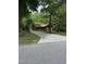 Charming cabin nestled amongst tall trees with a patterned driveway leading to the home at 5601 Plum Nearly Ct, Raleigh, NC 27610