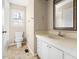 Classic bathroom featuring tiled floor, vanity, window and toilet offering essential amenities in neutral tones at 5802 Newhall Rd, Durham, NC 27713