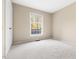 Neutral bedroom showcasing plush carpet, a large window offering natural light, and a spacious closet at 5802 Newhall Rd, Durham, NC 27713