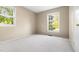 Bright bedroom showcasing plush carpet, two large windows offering natural light, and a spacious closet at 5802 Newhall Rd, Durham, NC 27713