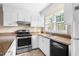 Kitchen featuring stainless steel oven, black dishwasher and large window above the sink at 5802 Newhall Rd, Durham, NC 27713