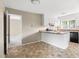 Open kitchen with white cabinets, black appliances, and a breakfast bar at 5802 Newhall Rd, Durham, NC 27713