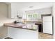 Well-lit kitchen featuring white cabinets, granite countertops, and a breakfast bar at 5802 Newhall Rd, Durham, NC 27713