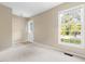 Bright, carpeted living space with a large window providing natural light and exterior views at 5802 Newhall Rd, Durham, NC 27713