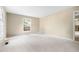 Carpeted living room featuring neutral tones, large window, and ample natural light at 5802 Newhall Rd, Durham, NC 27713