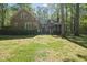 The backyard shows the home's spacious lawn, brick exterior, screened porch and wooden deck at 6000 Canadero Dr, Raleigh, NC 27612