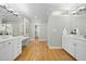 This bathroom features a double sink, a vanity, wooden floors, and two doors at 6000 Canadero Dr, Raleigh, NC 27612