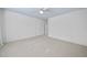 Bright bedroom with white walls, light carpet, and multiple doorways at 6000 Canadero Dr, Raleigh, NC 27612