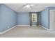 Inviting bedroom featuring blue walls, neutral carpet, and a window with curtains, for a cozy retreat at 6000 Canadero Dr, Raleigh, NC 27612