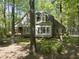 Lovely exterior view of a two-story home with large windows and dormers nestled among mature trees at 6000 Canadero Dr, Raleigh, NC 27612