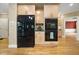 Kitchen with sleek black appliances, light wood cabinetry and a view to the living space at 6000 Canadero Dr, Raleigh, NC 27612