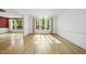 Bright living room with hardwood floors, large windows, and view to formal dining at 6000 Canadero Dr, Raleigh, NC 27612