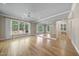 Spacious living room with hardwood floors, a ceiling fan, large windows, and mirrored walls at 6000 Canadero Dr, Raleigh, NC 27612