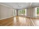 Spacious living room with hardwood floors, a ceiling fan, large windows, and mirrored walls at 6000 Canadero Dr, Raleigh, NC 27612