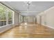 Spacious living room with hardwood floors, a ceiling fan, large windows, and mirrored walls at 6000 Canadero Dr, Raleigh, NC 27612