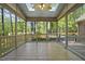 Screened-in porch with wood floors, a ceiling fan, and large glass windows at 6000 Canadero Dr, Raleigh, NC 27612