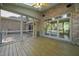 Screened-in porch with wood floors, brick exterior, and open views of the property at 6000 Canadero Dr, Raleigh, NC 27612