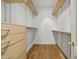Walk in closet with adjustable shelving and drawers and wooden floors at 6000 Canadero Dr, Raleigh, NC 27612