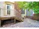 A cozy patio with access to the home's back entrance, wooden stairs, and brick chimney at 6000 Tenter Banks Sq, Raleigh, NC 27609
