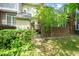 A lush backyard with vibrant greenery, a charming brick-wall, and a gated entrance to the lawn at 6000 Tenter Banks Sq, Raleigh, NC 27609